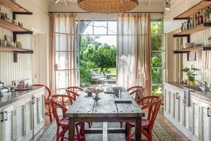Un generoso lote de ventanas de demolición proveyó cerramientos y, también, los postigos que cierran el bajomesada. Mesa de un antiguo taller de costura.