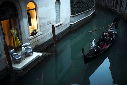 Un gondolero rema con clientes a lo largo de uno de los canales de Venecia, el sábado 29 de febrero de 2020.
