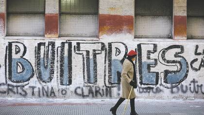 Un grafiti llama buitres a los fondos de cobertura por aprovecharse de los problemas del país. Ahora esas firmas ganan dinero alapostar a la recuperación de la economía