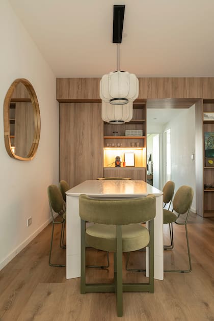 Un gran mueble con puerta corrediza en melamina ‘Scotch’ (Faplac) que reúne coffee station y espacio para vajilla, mantelería y ropa de cama. Colgantes (CapsulaLamp) y espejo (Bonhomía Haus).