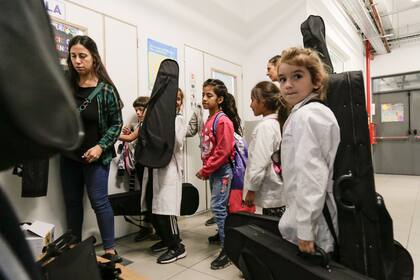 Un grupo de alumnos se prepara para comenzar con el taller de música, en donde aprenden chelo y violín
