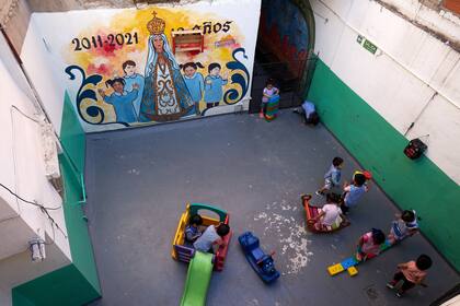 Un grupo de chicos y chicas juega en el patio del jardín de infantes del colegio ubicado en el Barrio Ricciardelli