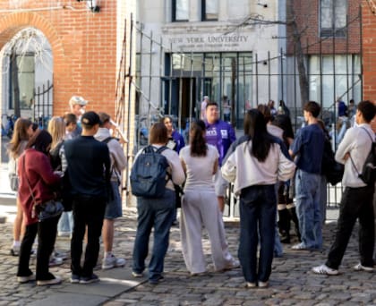 Un grupo de estudiantes se reúne frente a un edificio de NYU en una actividad organizada por iniciativas que promueven la interacción cara a cara