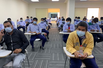 Un grupo de hombres espera ser vacunado contra el Covid-19 en Dubai el 8 de febrero de 2021