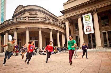 Un grupo de jóvenes ensaya una performance fuera del Teatro Solís.