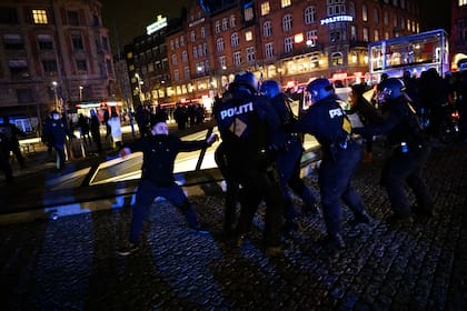 Un grupo de manifestantes que se hacen llamar "Hombres de Negro" se enfrentan a la policía mientras se manifiestan contra las restricciones del coronavirus en la plaza del ayuntamiento y en las calles laterales que conducen a la plaza de Copenhague el 9 de enero de 2021