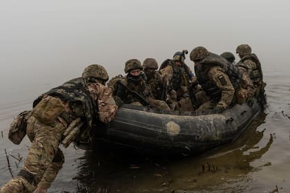 Un grupo de marines ucranianos, a bordo de una balsa, parten de una orilla del río Dniéper, en el frente, cerca de Jersón, Ucrania, el 14 de octubre de 2023. (AP Foto/Alex Babenko)