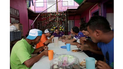 Un grupo de migrantes come en las instalaciones de Las Patronas antes de continuar su viaje en el tren ¨La Bestia¨