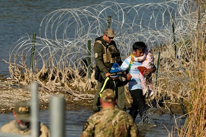 Un grupo de migrantes es detenido por oficiales en la frontera entre Texas y México 