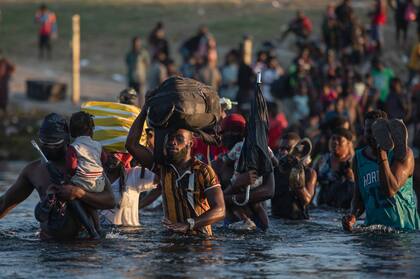 Un grupo de migrantes, muchos de ellos de Haití, cruzan el río Bravo desde Del Rio, Texas, para regresar a Ciudad Acuña, México, con el fin de evitar ser deportados por Estados Unidos. (Archivo AP Foto/Félix Márquez)