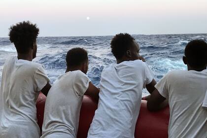 Un grupo de migrantes rescatados miran el mar el 14 de agosto de 2019, durante una operación de búsqueda y rescate en el Mediterráneo Mar