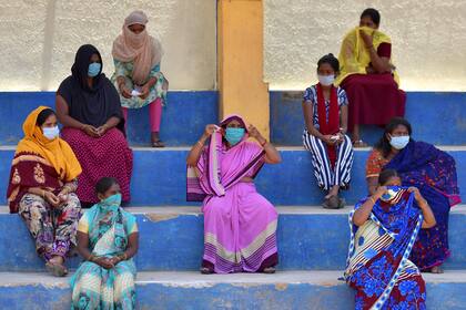 Un grupo de mujeres espera su turno para recibir alimentos gratuitos distribuidos por el Congreso del Estado de Karnataka durante el cierre nacional impuesto por el gobierno contra la propagación del coronavirus, en Bangalore el 21 de abril de 2020