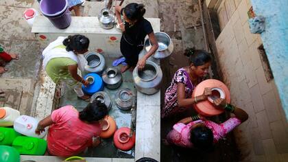 Un grupo de mujeres junta agua en jarras en Mumbai, India
