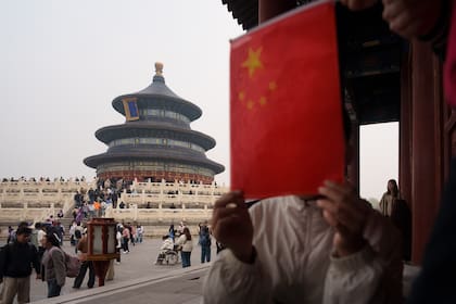 Un grupo de niños sostiene una bandera nacional china cerca del Salón de Oración por las Buenas Cosechas, en el Templo del Cielo