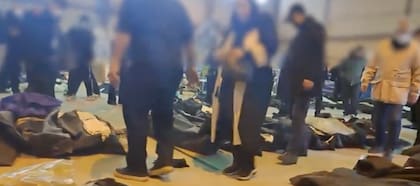 Un grupo de personas busca entre los cuerpos en la morgue de Kahrizak para identificar a sus seres queridos.