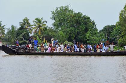 Un grupo de personas espera en un bote ser rescatadas por los grupos socorristas