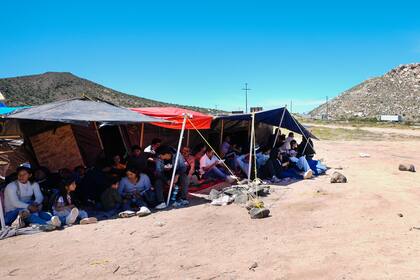 Un grupo de personas esperan a ser procesadas después de cruzar la frontera entre México y Estados Unidos