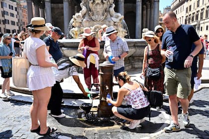Un grupo de personas hace cola para llenar una botella de agua en un grifo público de la Piazza della Rotonda de Roma el 11 de julio de 2023.