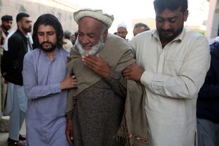 Un grupo de personas llora la muerte de su familiar, un agente de policía asesinado en el atentado suicida perpetrado el lunes en el interior de una mezquita, en Peshawar, Pakistán, martes 31 de enero de 2023.