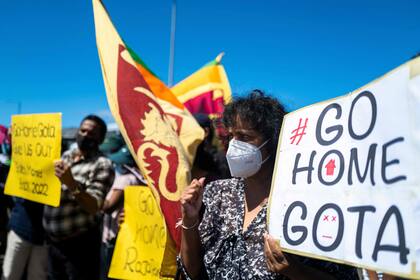 Un grupo de personas muestra pancartas durante una manifestación antigubernamental frente a la oficina del presidente en Colombo el 15 de abril de 2022, en la que se exige la dimisión del presidente Gotabaya Rajapaksa por la agobiante crisis económica del país. 