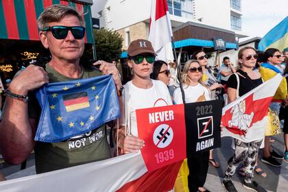 Un grupo de personas ondea banderas europeas y ucranianas durante una manifestación en solidaridad con Ucrania en la ciudad portuaria de Limassol, al sur de Chipre, mientras los europeos conmemoran la victoria de los Aliados contra la Alemania nazi y el fin de la Segunda Guerra Mundial en Europa (Día de la Victoria), el 8 de mayo de 2022.