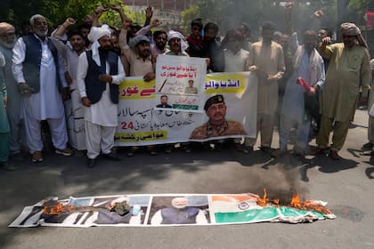 Un grupo de personas protestan quemando un cartel del primer ministro indio Narendra Modi y una bandera india en Lahore, Pakistán, el 27 de abril de 2025