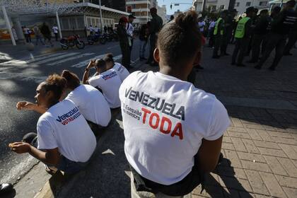 Un grupo de personas que llevan camisetas con el lema "Toda Venezuela, El Esequibo es nuestro" se encuentran afuera de una mesa electoral durante el referéndum sobre el reclamo de Venezuela sobre el disputado territorio del Esequibo