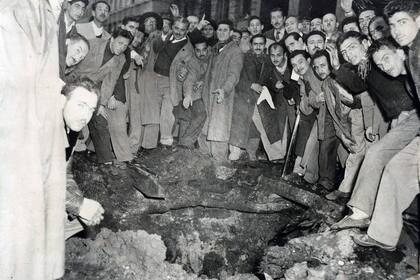 Un grupo de personas rodean uno de los cráteres que dejaron los ataques con bombas realizados por parte de la aviación naval contra el gobierno de Juan Domingo Perón