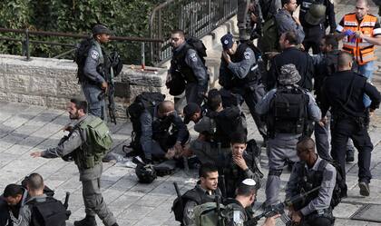 Un grupo de policías ayuda a un agente herido, en Jerusalén