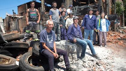 Un grupo de trabajadores de la cooperativa junto a Cecilia Lee, su fundadora, sobre los escombros que dejó el fuego