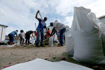 Un grupo de voluntarios llena sacos de arena para los residentes mientras la ciudad se prepara para el huracán Laura, en Nueva Orleans, Luisiana