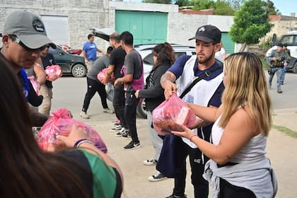 Un grupo de voluntarios reparte alimentos en un barrio popular afectado por las inundaciones. Foto: Municipalidad de Bahía Blanca