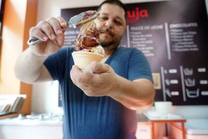 Un heladero de Jauja en acción sumando dulce de leche con frambuesas al Sauco de la pasión