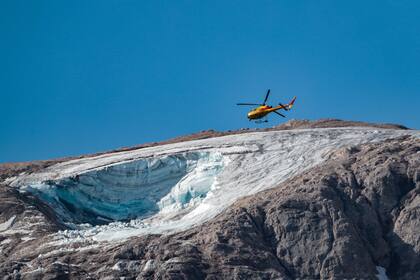 Un helicóptero de rescate vuela el 4 de julio de 2022 sobre el glaciar que se derrumbó el día anterior en la montaña de Marmolada, la más alta de los Dolomitas