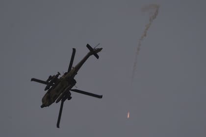 Un helicóptero israelí lanza bengalas mientras sobrevuela la frontera entre Israel y Gaza, visto desde el sur de Israel, el lunes 12 de febrero de 2024.