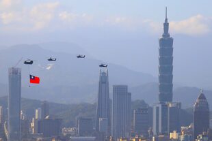 Un helicóptero militar con una bandera de Taiwán realiza un ensayo de sobrevuelo con otros helicópteros antes de la celebración del Doble Décimo Día Nacional en medio de las crecientes amenazas militares de China