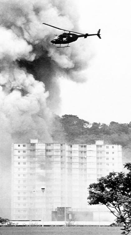 Un helicóptero militar estadounidense sobrevoló edificios en llamas en Ciudad de Panamá en diciembre de 1989. (ARCHIVO-AP)