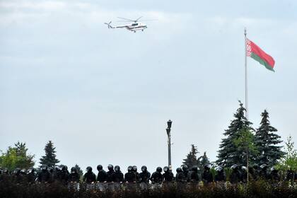 Un helicóptero que se cree que transporta al presidente bielorruso, Alexander Lukashenko, sobrevuela a los agentes frente al Palacio de la Independencia durante una manifestación de partidarios de la oposición para protestar contra los resultados de las elecciones presidenciales en disputa en Minsk 