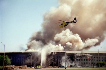 Un helicóptero vuela sobre el Pentágono en Washington mientras sale humo del edificio el 11 de septiembre de 2001 tras el impacto