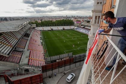Un hincha de Rayo Vallecano observa el partido con barbijo desde el balcón de su casa