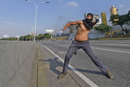 Un hombre arroja piedras durante los enfrentamientos