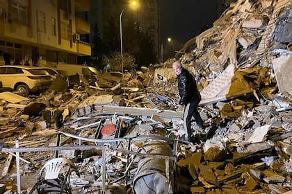 Un hombre busca en edificios derrumbados en Diyarbakir, sur de Turquía, a primera hora del lunes 6 de febrero de 2023