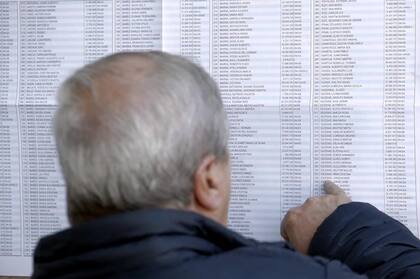 Un hombre busca su lugar de votación en las planillas pegadas en la fachada de un colegio de Mar del Plata