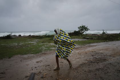 Un hombre camina bajo la lluvia antes de la llegada del huracán Melissa, en Canizo, una localidad en Santiago de Cuba