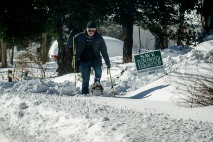 Un hombre camina con raquetas de nieve después de que una tormenta de nieve azotara el noreste el 30 de enero de 2022 en Centereach, Nueva York. Una poderosa tormenta del nordeste trajo cegadoras condiciones de ventisca con fuertes vientos que causaron algunos cortes de energía en la costa del Atlántico Medio y Nueva Inglaterra.