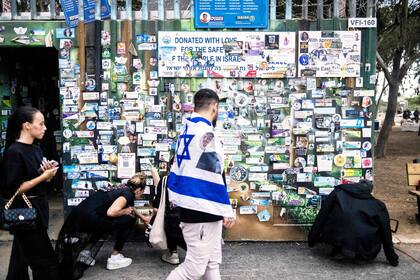 Un hombre camina frente a un refugio antiaéreo cubierto de pegatinas de israelíes muertos en el memorial del festival Nova, cerca del kibutz Reim, en el sur de Israel