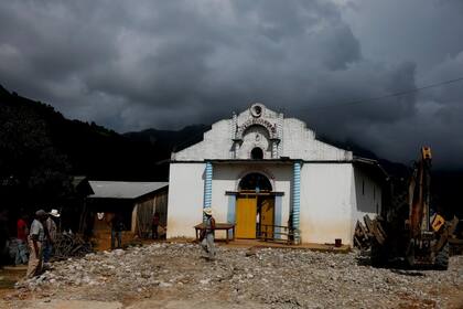 Un hombre camina frente a una iglesia local de Yucucani