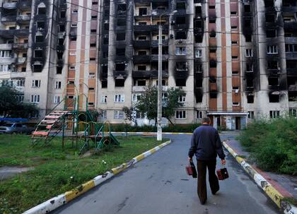 Un hombre camina hacia un edificio residencial dañado en la ciudad de Irpin el 11 de septiembre de 2022, en medio de la invasión rusa de Ucrania.