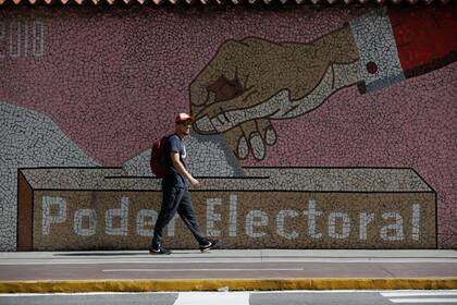 Un hombre camina junto a la sede del Consejo Nacional Electoral en Caracas