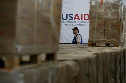 Un hombre camina junto a varias cajas de ayuda humanitaria de Usaid en un almacén de la Brigada Internacional Tienditas, en las afueras de Cúcuta, Colombia, el 21 de febrero de 2019, en la frontera con Venezuela. (AP/Fernando Vergara, Archivo)